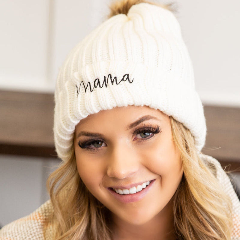 Woman wearing a white 'mama' beanie and smiling.
