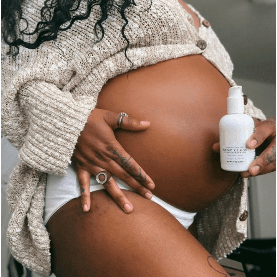 Pregnant person holding a bottle of 'Bump Glow' skincare product.