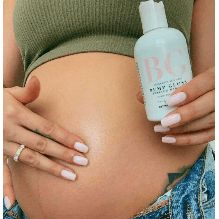 Pregnant mom holding a bottle of 'Bump Gloss' against their stomach.