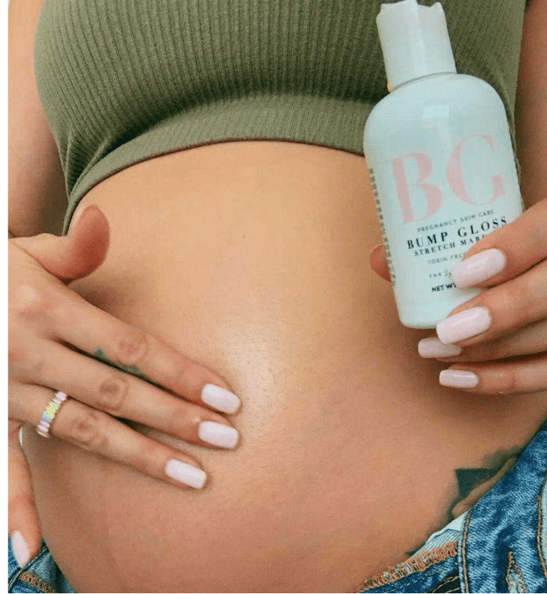 Pregnant mom holding a bottle of 'Bump Gloss' against their stomach.