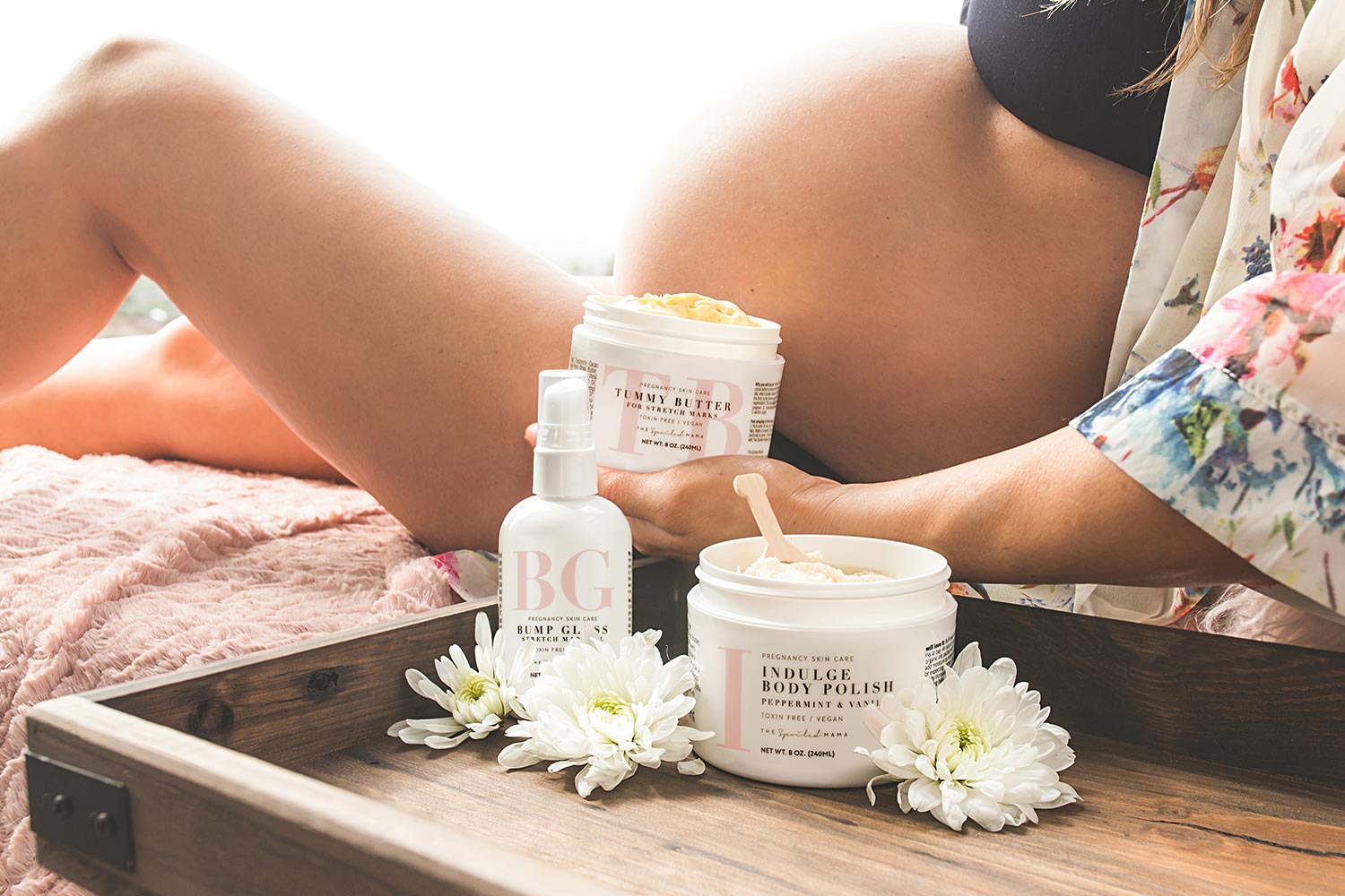 Pregnant woman using The Spoiled Mama Tummy Butter, Bump Gloss, and Body Polish as part of a daily pregnancy skincare routine for healthy-looking, hydrated skin.