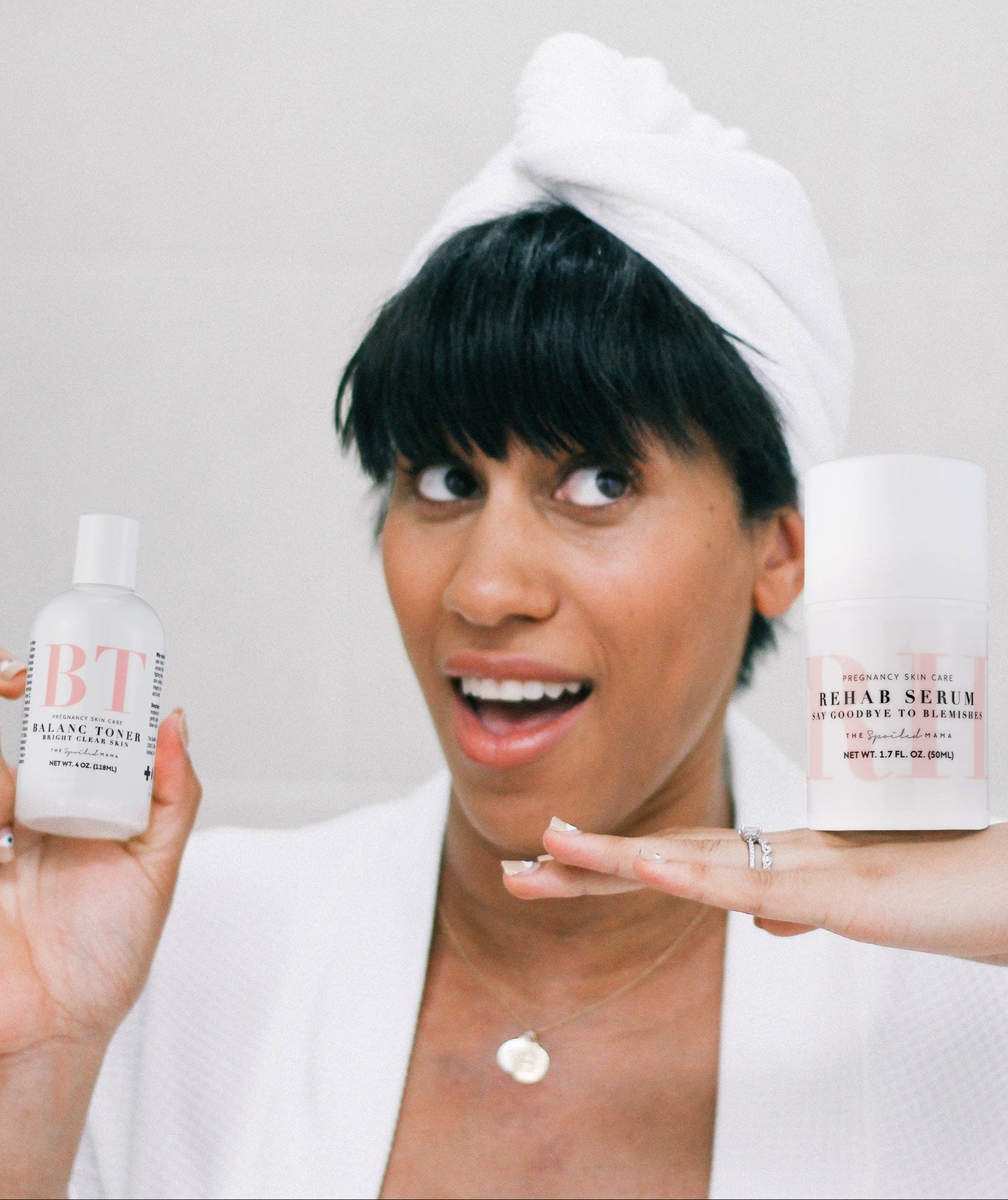 Woman holding BalanC Acne Toner and ReHab Acne Serum with a neutral background