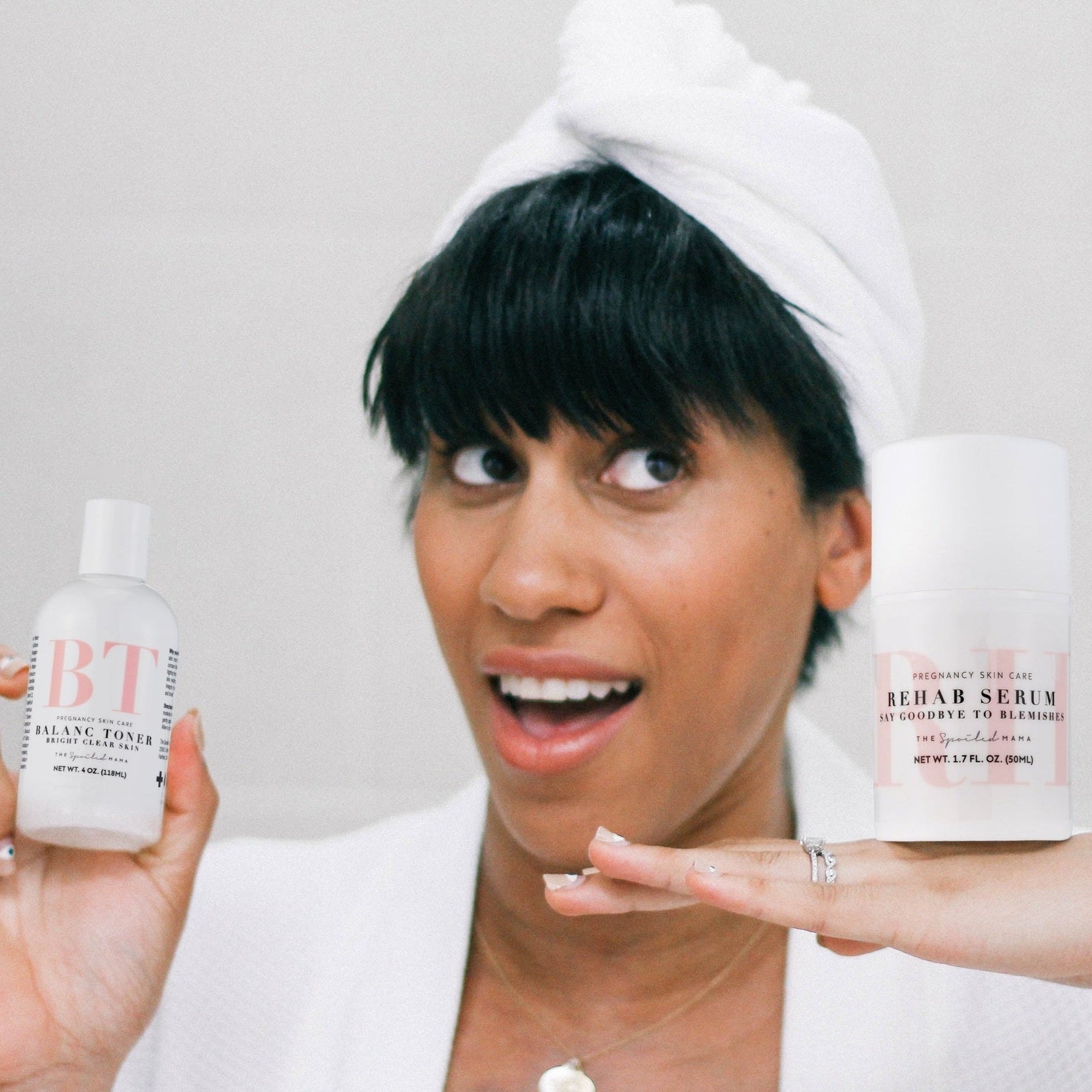 Woman holding BalanC Acne Toner and ReHab Acne Serum with a neutral background
