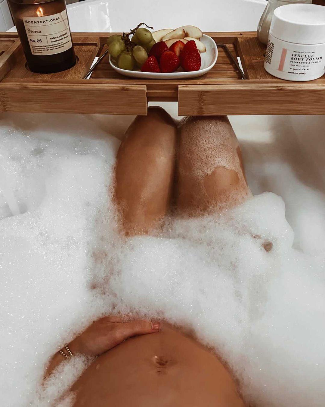 Pregnant woman enjoying a relaxing bath with The Spoiled Mama pregnancy-safe skincare products formulated without sulfates, parabens, phthalates, synthetic fragrance, or other ingredients commonly avoided during pregnancy.