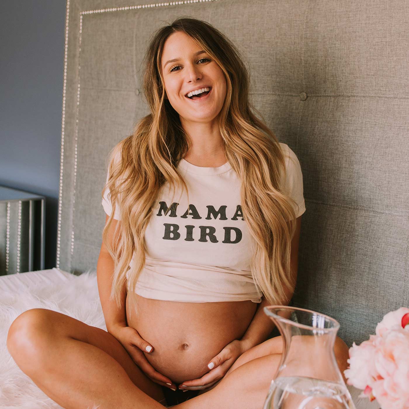 Pregnant mother smiling while supporting The Spoiled Mama's commitment to sustainable manufacturing, responsible sourcing, and recyclable packaging.