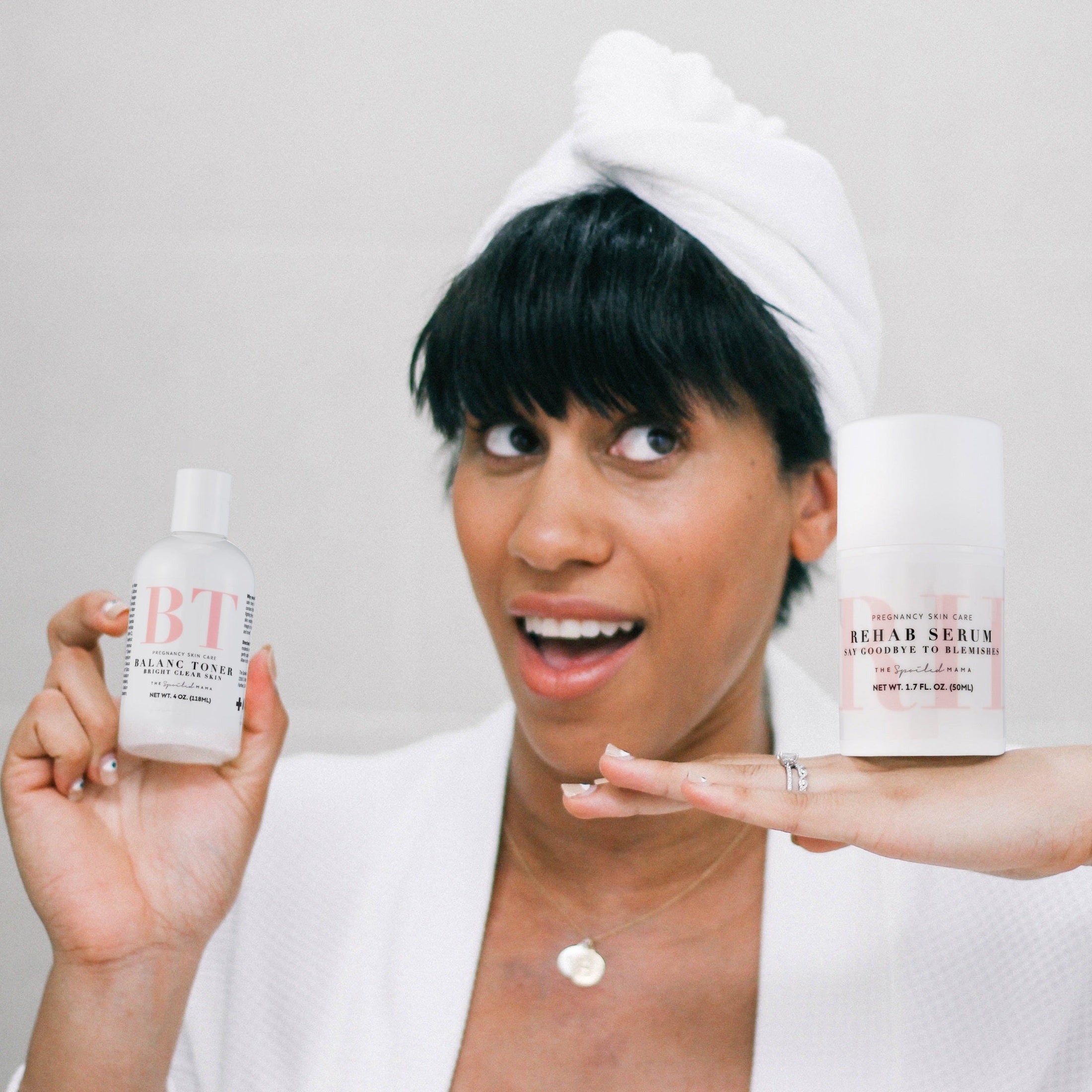 Woman holding BalanC Acne Toner and ReHab Acne Serum with a neutral background